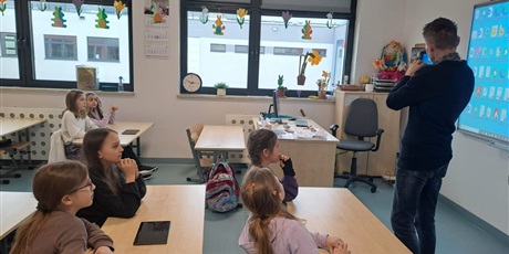 Powiększ grafikę: Nauczyciel informtyki/wicedyrektor Bartosz Chyś pokazuje tablet uczniom w klasie