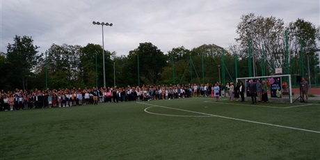 Powiększ grafikę: Uczniowie z wychowawcami stoją na boisku szkolnym.