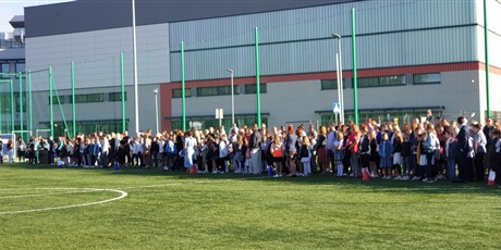 Powiększ grafikę: Uczniowie stoją na boisku szkolnym