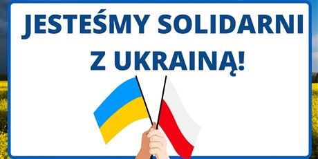 Powiększ grafikę: Plakat pt. "Jesteśmy solidarni z Ukrainą". Na dole dwie flagi w dłoniach: ukraińska i polska