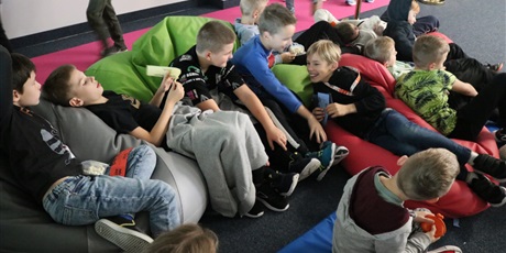 Powiększ grafikę: Uczniowie przed seansem filmowym siedzą na auli szkolnej