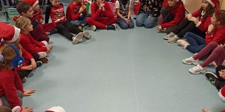 Powiększ grafikę: Uczniowie 2i siedzą w kółku na podłodze z wychowawczynią