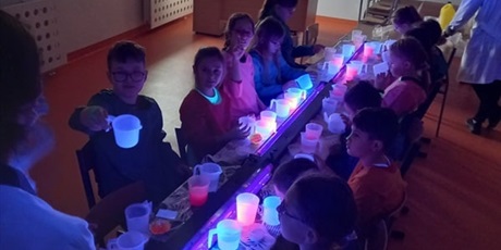 Powiększ grafikę: Dzieci podczas warsztatów z fluorescencyjnymi slime.