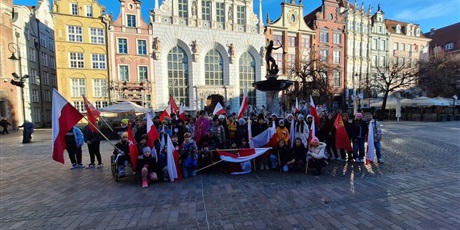 Powiększ grafikę: Uczniowie z flagami przy pomniku Neptuna w Gdańsku