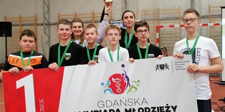Powiększ grafikę: Nagrodzeni uczniowie z medalami  trzymają transparent  promujący zawody Gdańskiej Olimpiady Młodzieży
