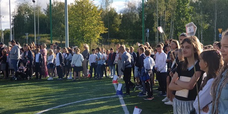 Powiększ grafikę: Uczniowie stoją na boisku szkolnym