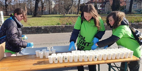 Powiększ grafikę: Wolontariuszki przygotowują wodę dla biegaczy