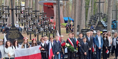 Powiększ grafikę: Delagacja ucnzió -wolontariuszy z opiekunkami na tel cmentarza, trzymają flagę polską.