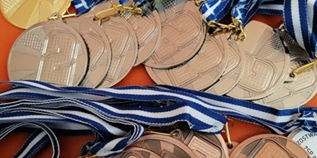 Powiększ grafikę: Przygotowane nagrody-złote medale leżą na stole